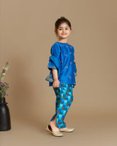young girl wearing  Laad`s  vibrant blue embroidered kurta with delicate floral motifs, paired with checkered blue and green patiala pants and a matching dupatta with gold detailing.